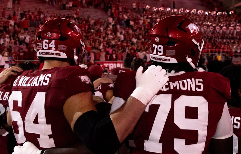 Linemen 64 and 79 embrace, seen from behind